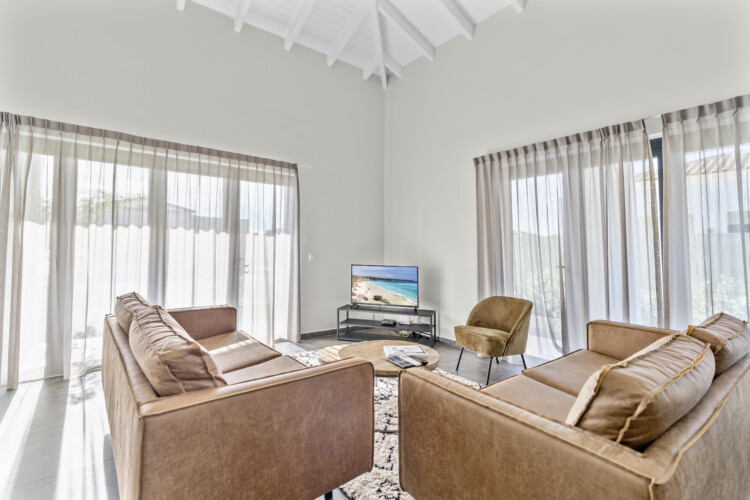 Bright living room with comfortable seating and Smart TV at Villa Blenchi Curaçao