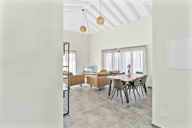 Bright dining area at Villa Blenchi Curaçao with large table and garden view